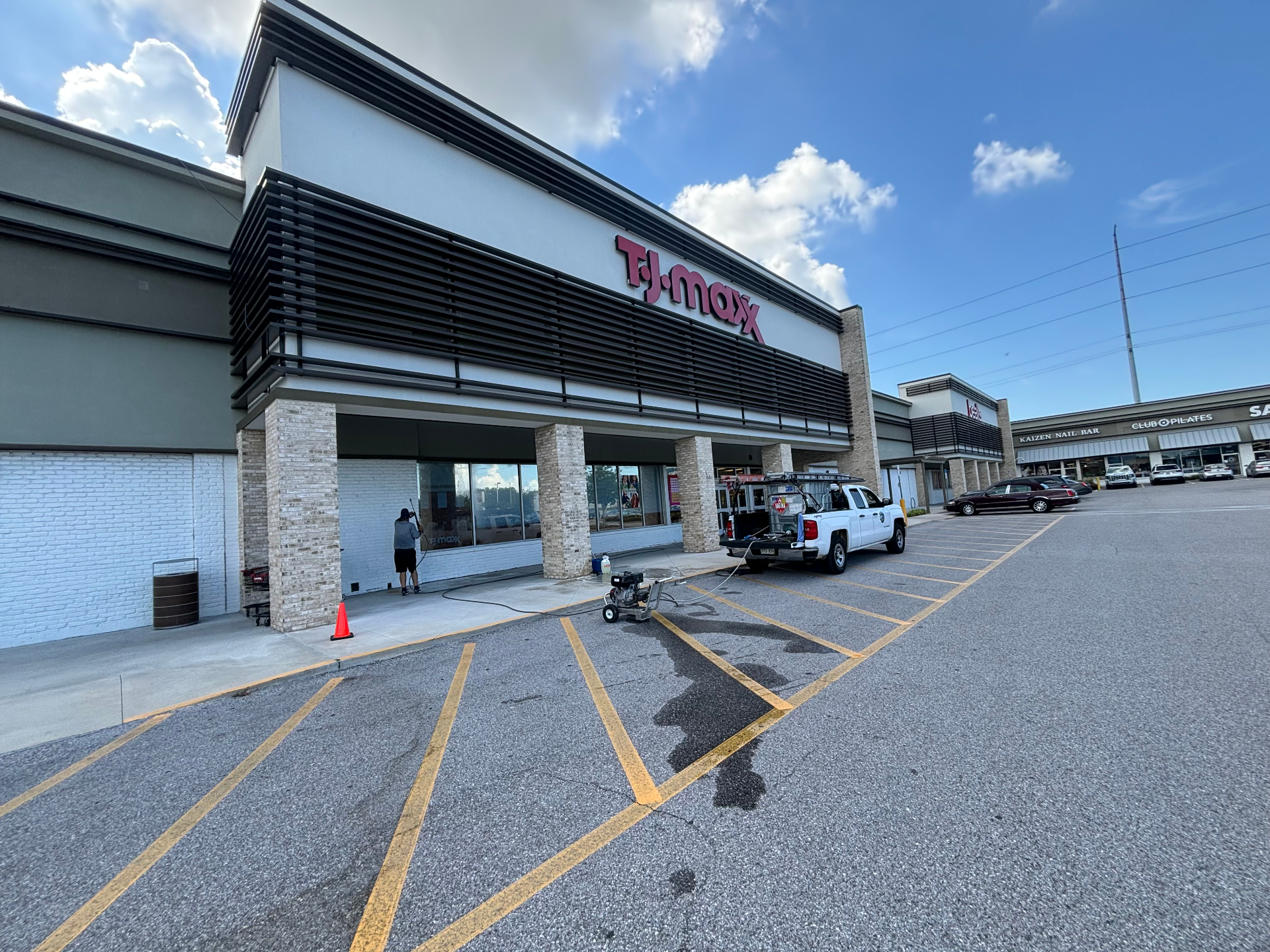 Bayside crew pressure washing a commercial retail storefront in Tampa